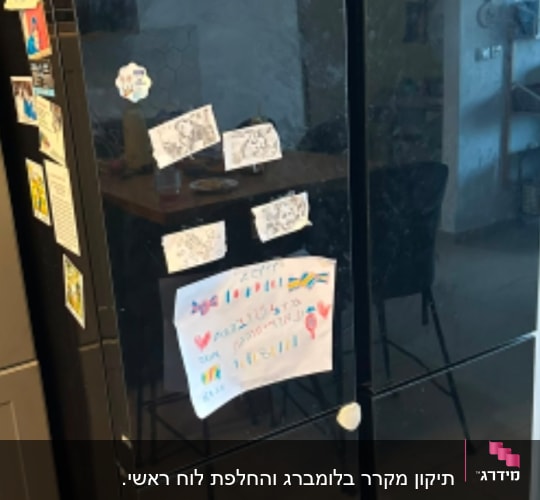 מקרר שחור עם מגנטים וציורים